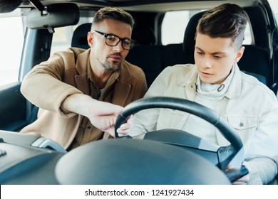 Handsome Father Teaching Teen Son Driving Car