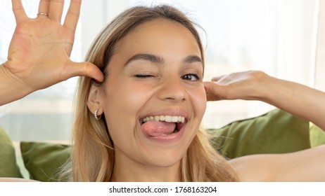 Handsome Female Making Funny Faces On Her Couch At Home. Being Silly And Playful Like A Child. 