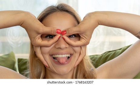 Handsome Female Making Funny Faces On Her Couch At Home. Being Silly And Playful Like A Child. 