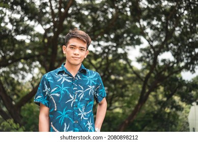 A handsome Filipino man in a casual tropical polo shirt. Copy space on right side of photo.