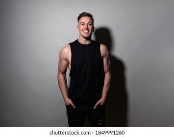 Handsome And Fit Bodybuilder Posing On Black Background In Workout Gear