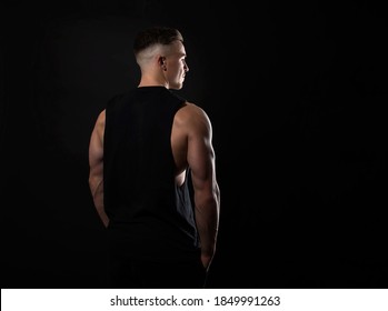 Handsome And Fit Bodybuilder Posing On Black Background In Workout Gear