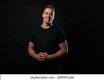 Handsome And Fit Bodybuilder Posing On Black Background In Workout Gear