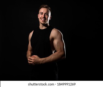 Handsome And Fit Bodybuilder Posing On Black Background In Workout Gear