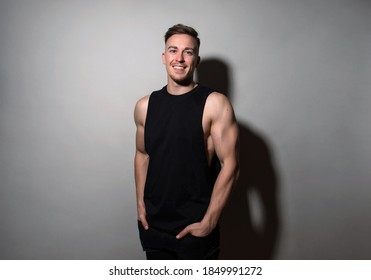 Handsome And Fit Bodybuilder Posing On Black Background In Workout Gear