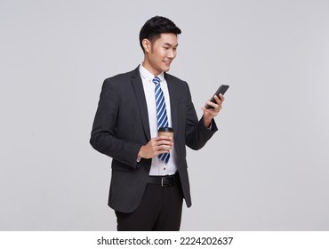 Handsome and friendly face asian businessman smile in formal suit his using smartphone on white background studio shot. - Powered by Shutterstock