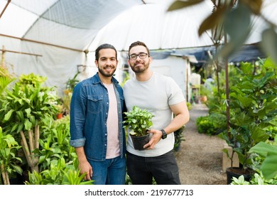 Handsome Gay Couple With A Gardening Hobby At The Nursery Garden Smiling While Buying New Plants Together