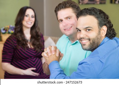 Handsome Gay Men Holding Hands With Smiling Surrogate Mother