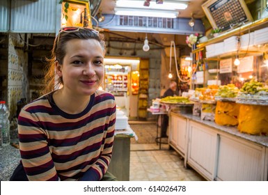 handsome girl tourist in Baklava and Knafeh shop on the souq in Jerusalem, Israel.