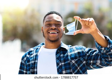 Handsome Glad Black Guy Girl Taking His Surgeon Mask Off Walking Down The Street In Downtown, Blurred Background