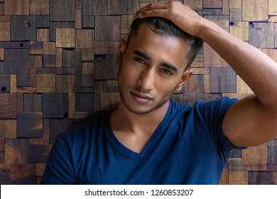 Handsome And Good Looking Arab Or Indian Male Model With Dark Hair And Dark Eyes, A Sharp Face And An Attractive Sexy Body With Muscles, Is Posing In A Blue Outfit For A Fashion Shoot