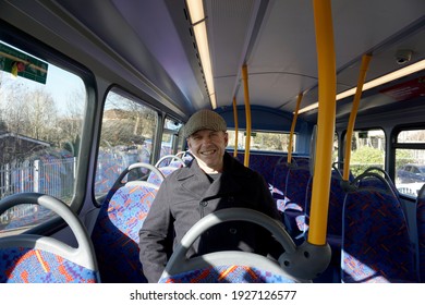 Schöner Kaukasischer Mann mit marineblau-blauer Jacke und tweed-flacher Mütze mit lächelndem Gesicht auf der zweiten Oberkante des roten Doppeldecker-Bus in London Vereinigtes Königreich