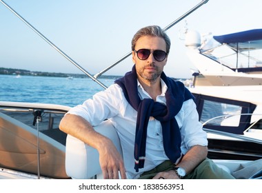 Handsome good looking mature man on the yacht. Portrait of successful man on sailing boat at sunset. - Shutterstock ID 1838563951
