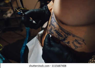 Handsome good looking professional tattoo artist makes a tattoo for himself - Shutterstock ID 1115687408