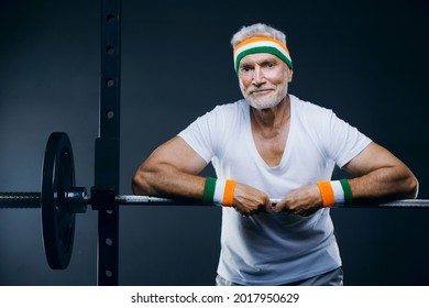 Handsome Gray Haired Senior Man With Head Band And Wristbands. Sport And Health Care Concept