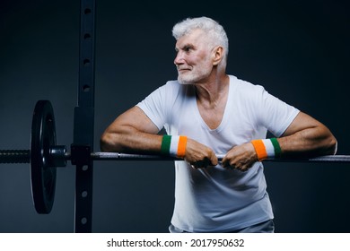 Handsome Gray Haired Senior Man With Head Band And Wristbands. Sport And Health Care Concept