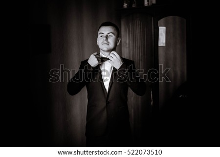 handsome groom getting dressed and preparing for the wedding