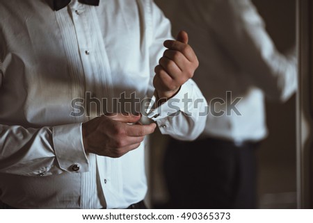 handsome groom prepares for ceremony