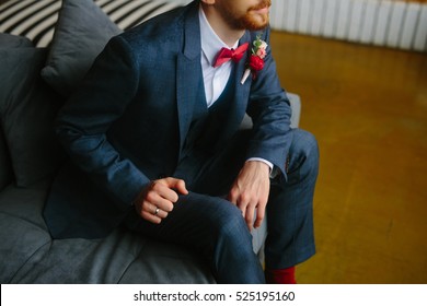 Handsome groom in a wedding tuxedo smiling and waiting for the bride. Rich groom on the wedding day. Elegant groom in a suit and bow tie. The groom suit, holding a lapel of his jacket. - Powered by Shutterstock