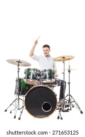 Handsome guy behind the drum kit on a white background in shirt and trousers