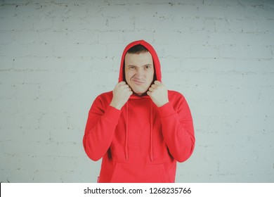 Handsome guy posing by a brick wall. Crazy man in a red hoodie - Powered by Shutterstock