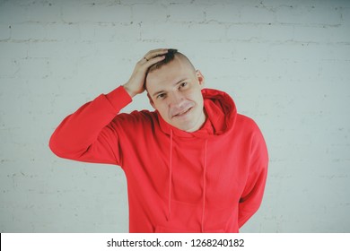 Handsome guy posing by a brick wall. Crazy man in a red hoodie - Powered by Shutterstock