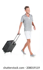 handsome guy walking with luggage and smiling. profile of man pulling bag on white background