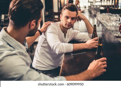 Handsome guys are drinking beer and talking while resting in pub - Shutterstock ID 609099950