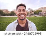 Handsome happy African American bearded man. Portrait of cheerful young man standing outdoors and smiling at camera. Positive emotion concept of male person. Generation z guy look carefree and natural