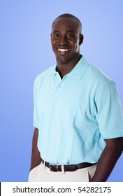 Handsome Happy African American Corporate Business Man Smiling, Wearing Blue Polo Shirt, Hands In Pocket, Standing, Isolated.