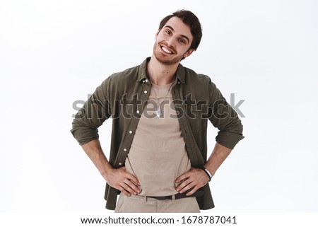 Handsome happy boyfriend tilt head and looking pleased camera, satisfied shopping with girlfriend at mall, checking-out outfit, agree with good choice, standing delighted white background