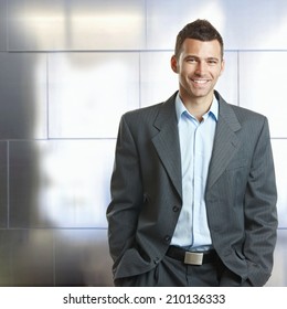 Handsome Happy Confident Caucasian Businessman Hands In Pocket, Suit With No Tie. Smiling, Standing, Looking At Camera,