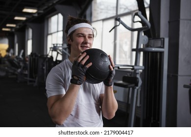 Handsome Happy Fitness Man Training With Medicine Ball At Sports Studio