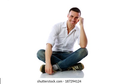 Handsome happy man sitting at the floor over white background