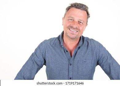 handsome happy smiling bearded man in casual blue shirt poses in studio on white background