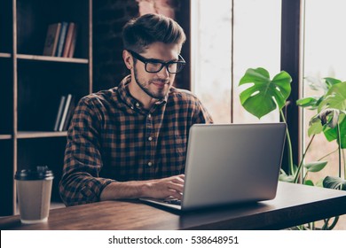 Handsome Happy Young Man In Glasses Typing On Laptop