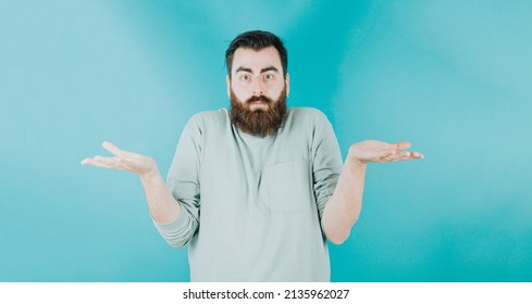 Handsome Hipster Bearded Looking Confused Not Knowing What To Think. Young Man Attitude Funny. Blue Tone Color Background, Expression Of Normal People. Mockup Concept With People