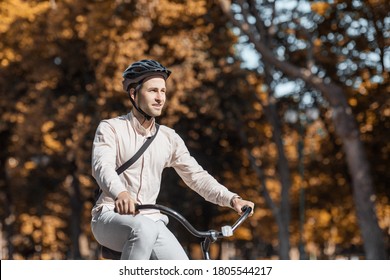 Handsome Hipster Cycling At City. Guy On Bike In Safety Helmet Ride To Work In Park, Copy Space