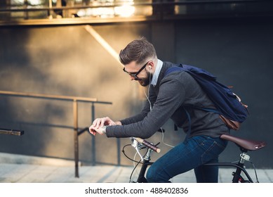 Handsome hipster enjoying a bike ride and checking time on his watch. - Powered by Shutterstock