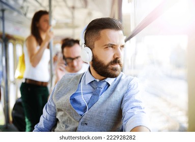 Handsome hipster modern man with headphones traveling by tram in town - Powered by Shutterstock