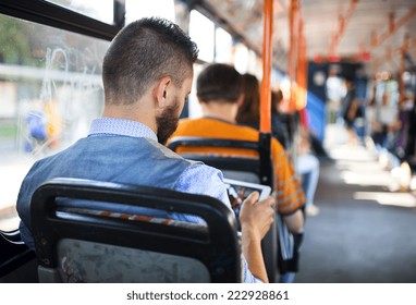 Handsome hipster modern man using digital tablet in tram