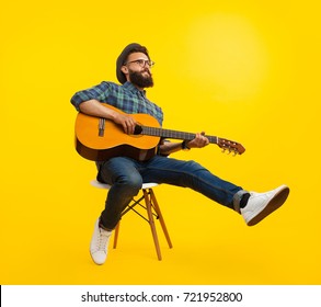 Handsome hipster musician man sitting and playing guitar.  - Powered by Shutterstock