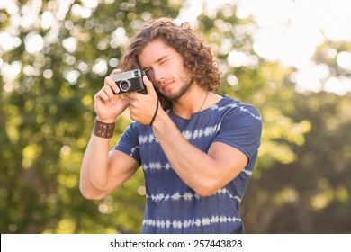 Handsome hipster using vintage camera on a sunny day - Powered by Shutterstock