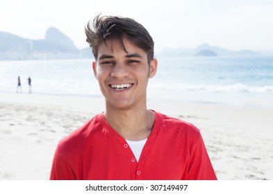 Handsome hispanic guy at beach looking at camera