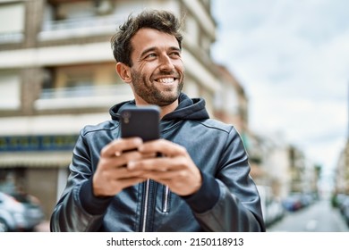 Handsome hispanic man with beard smiling happy outdoors using smartphone - Powered by Shutterstock