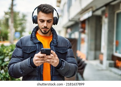 Handsome hispanic man with beard smiling happy and confident at the city wearing winter coat using smartphone - Shutterstock ID 2181637899