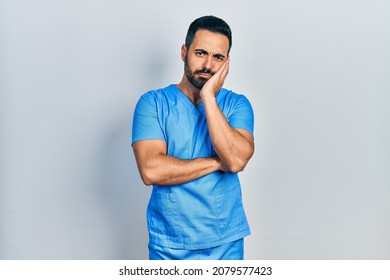 Handsome Hispanic Man With Beard Wearing Blue Male Nurse Uniform Thinking Looking Tired And Bored With Depression Problems With Crossed Arms. 