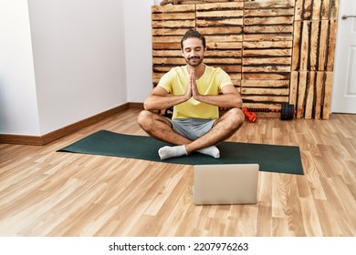 Handsome Hispanic Man Meditating With Video Tutorial On Laptop At The Gym