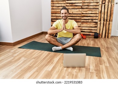 Handsome Hispanic Man Meditating With Video Tutorial On Laptop At The Gym