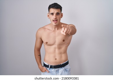 Handsome hispanic man standing shirtless pointing displeased and frustrated to the camera, angry and furious with you  - Powered by Shutterstock